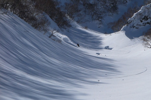 ハードコアなロングランを終え、ボトムの壁で豪快な雪しぶきを上げるナカイ。